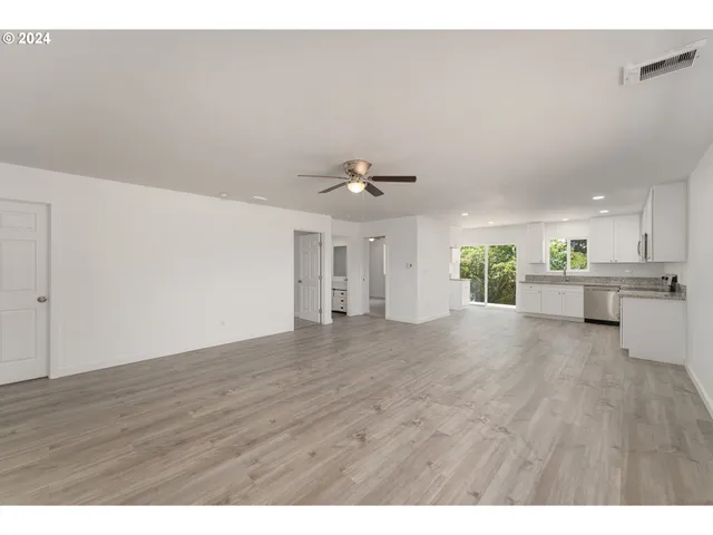 a view of an empty room with a kitchen