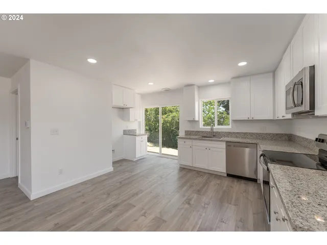 a kitchen with a refrigerator and wooden cabinets