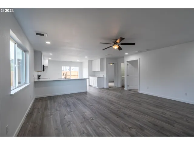 a view of an empty room and window and wooden floor
