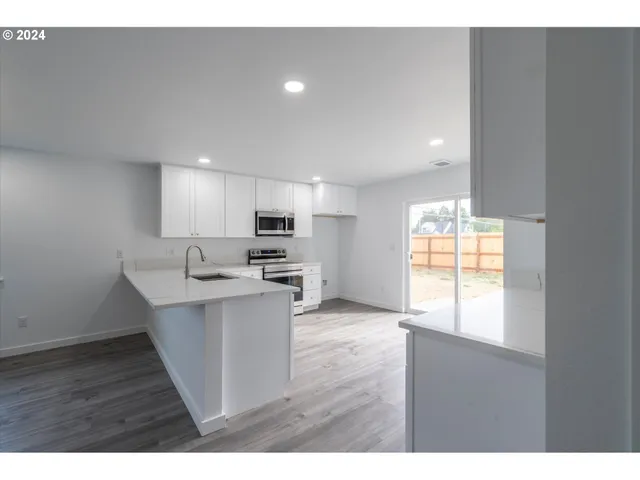 a open kitchen with stainless steel appliances granite countertop a sink and window