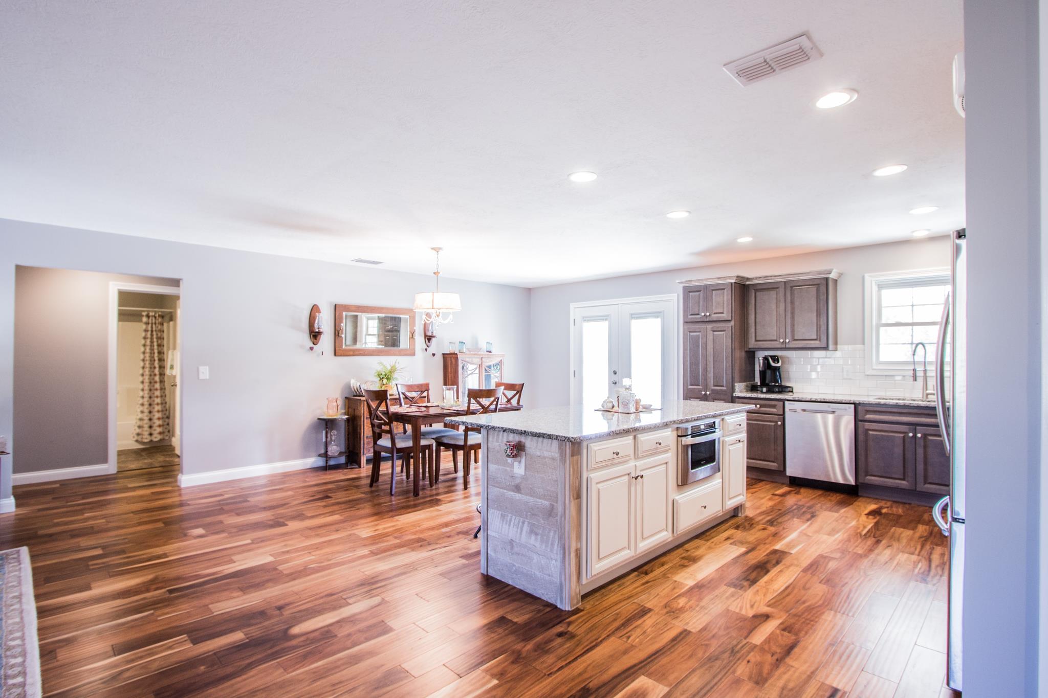 2082 Wayside Road Manchester, TN 37355 - Photo 8 of 30 a kitchen with stainless steel appliances granite countertop a stove top oven a sink dishwasher a dining table and chairs with wooden floor