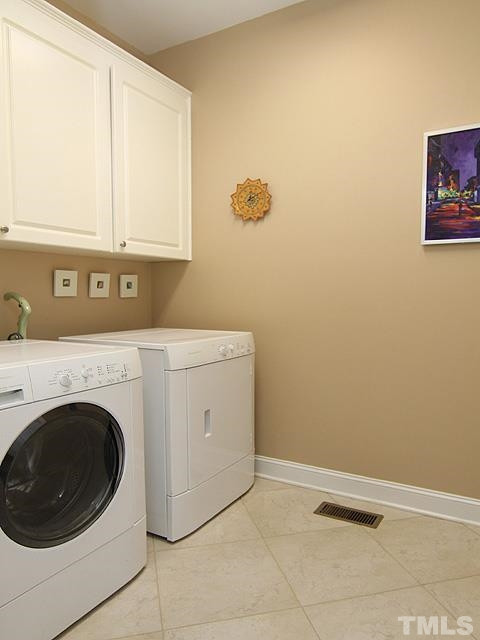 11618 John Allen Road Raleigh, NC 27614 - Photo 21 of 25 Laundry room on main floor, tile floor, plenty of storage in these cabinets for your laundry supplies, lots of room for folding your clothes! Laundry room