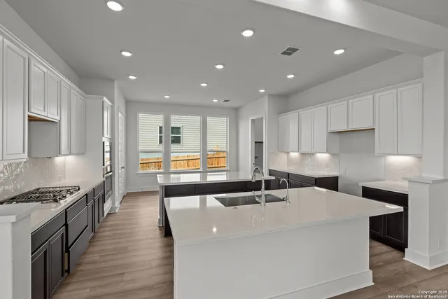a kitchen with stainless steel appliances granite countertop a sink and a stove top oven