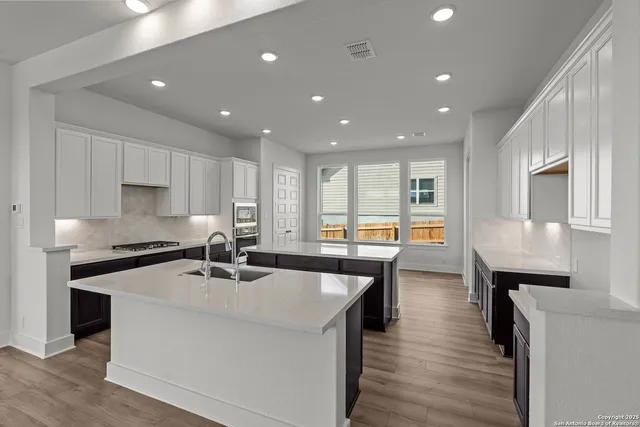 a kitchen with a sink stove and wooden floor