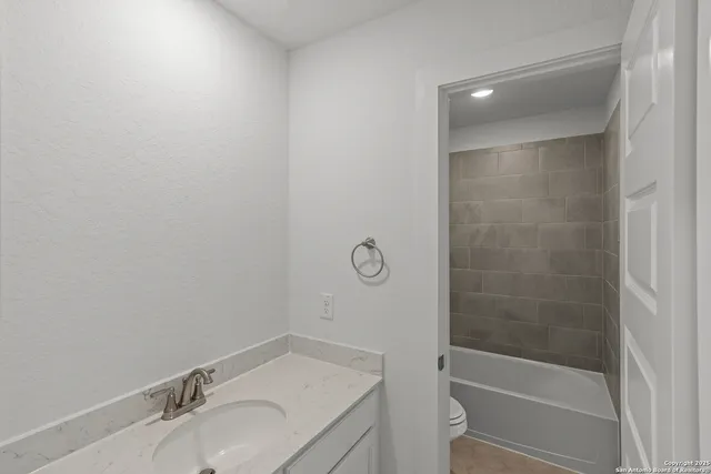 a bathroom with a granite countertop sink toilet and shower
