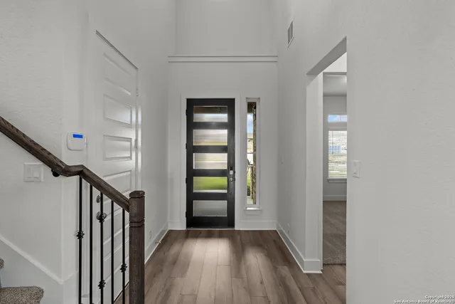 a view of an entryway with wooden floor and stairs