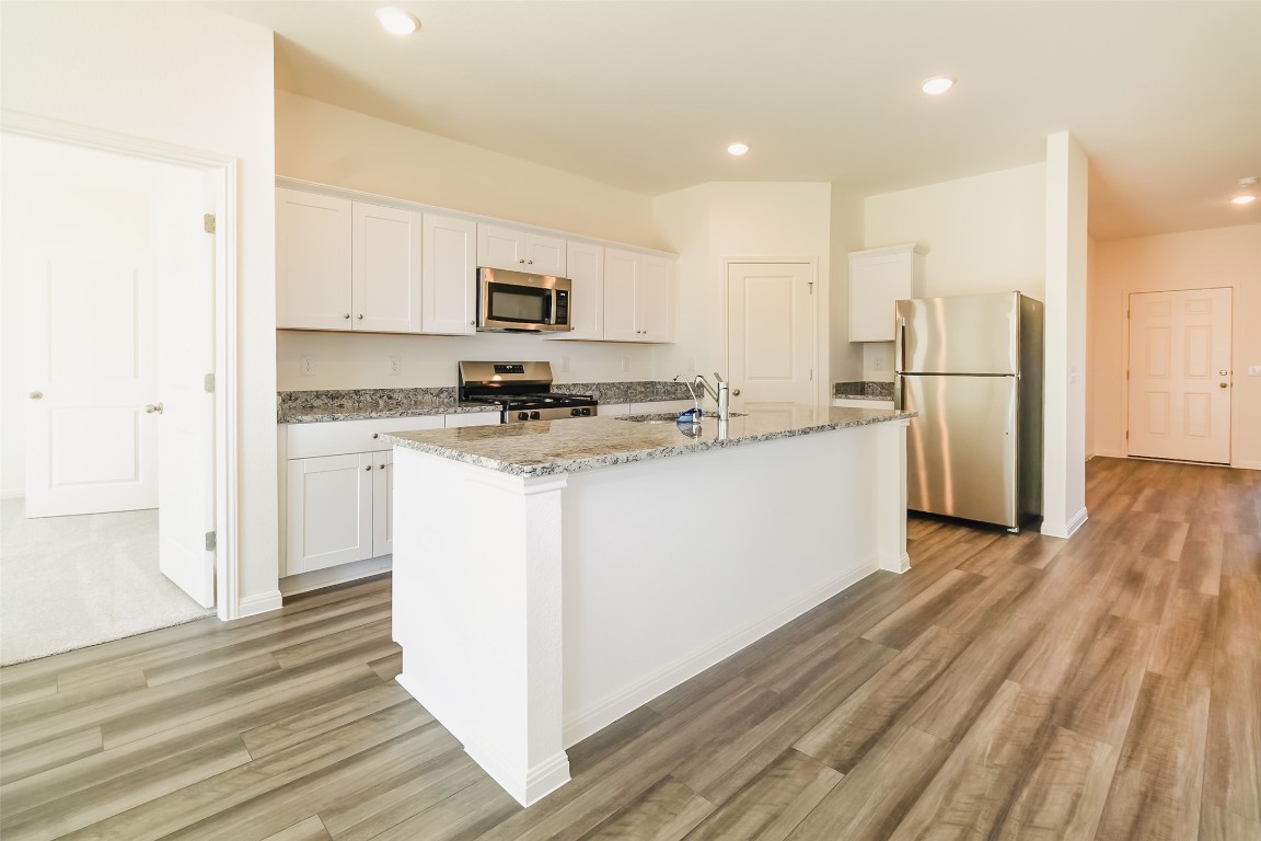 1524 Morris Loop San Marcos, TX 78666 - Photo 19 of 25 a kitchen with a refrigerator a stove top oven a sink and a center island
