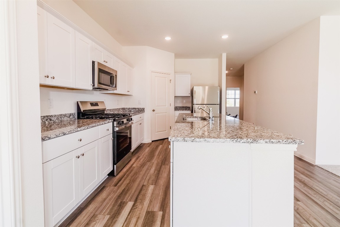 1524 Morris Loop San Marcos, TX 78666 - Photo 21 of 25 a kitchen with stainless steel appliances granite countertop a sink stove and cabinets