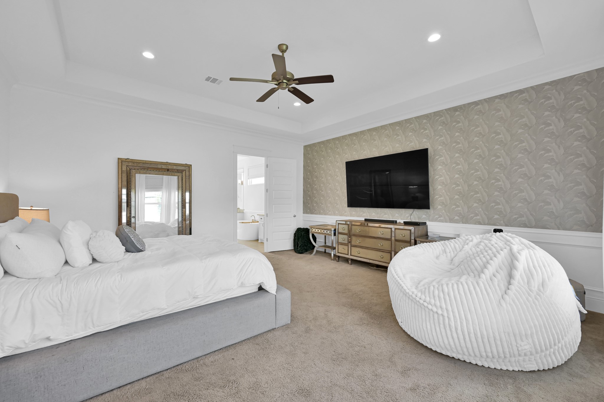 2333 Goldenglade Drive Conroe, TX 77384 - Photo 16 of 45 Spacious primary downstairs bedroom with elegant wallpaper and timeless style.