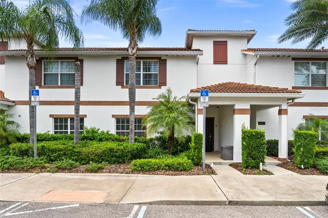 a front view of a house with a yard and palm trees