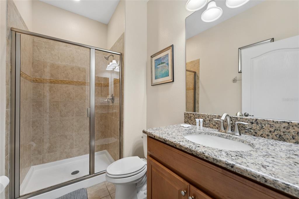 4841 Clock Tower Drive Kissimmee, FL 34746 - Photo 13 of 36 a bathroom with a granite countertop sink toilet and shower