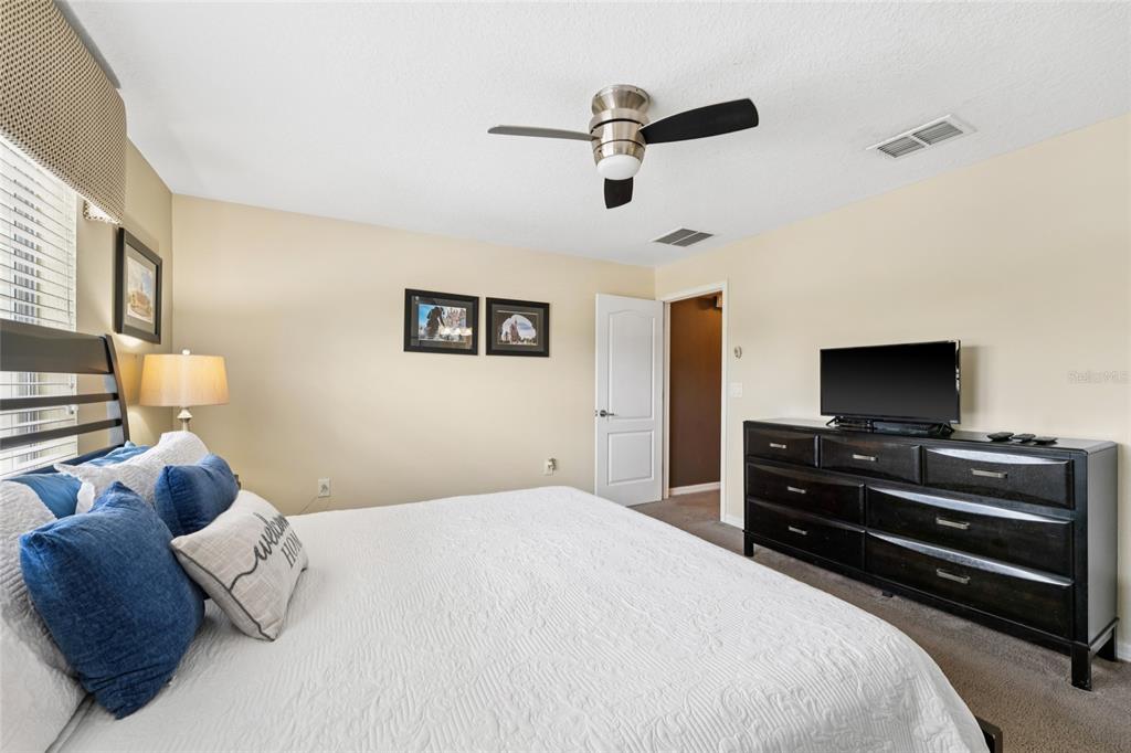 4841 Clock Tower Drive Kissimmee, FL 34746 - Photo 17 of 36 a bedroom with a bed and a flat screen tv
