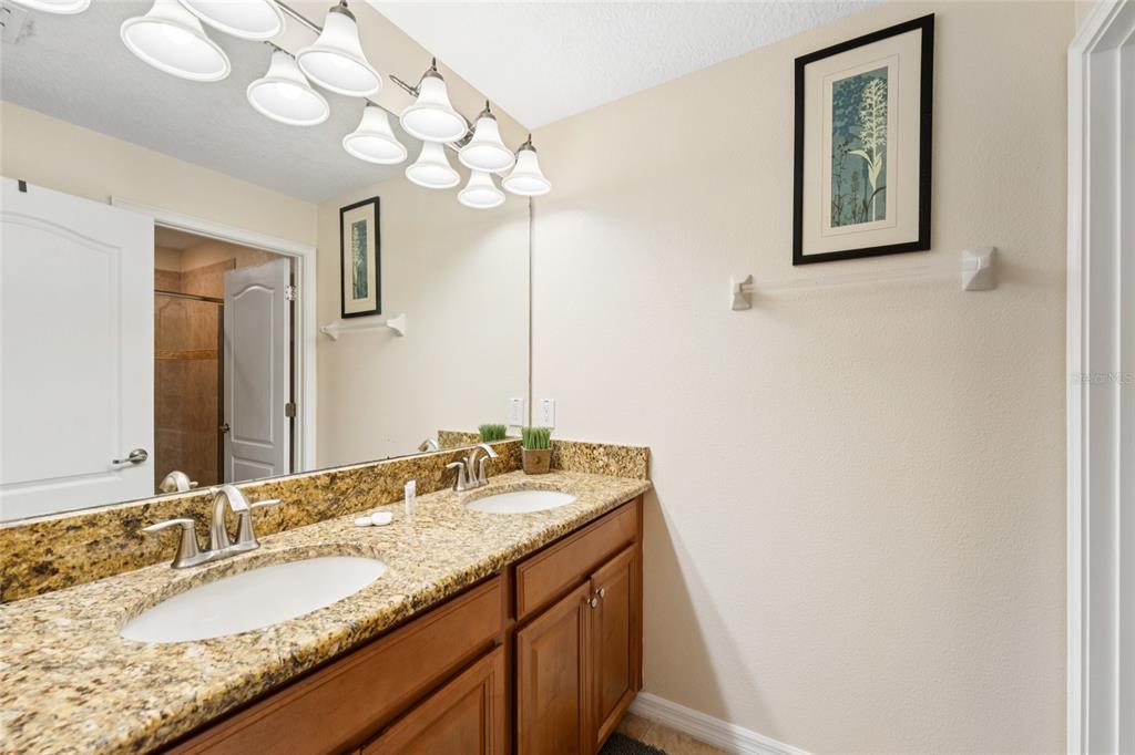 4841 Clock Tower Drive Kissimmee, FL 34746 - Photo 21 of 36 a bathroom with a granite countertop sink and a mirror