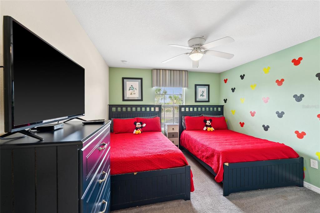 4841 Clock Tower Drive Kissimmee, FL 34746 - Photo 22 of 36 a bedroom with two beds and a flat screen tv