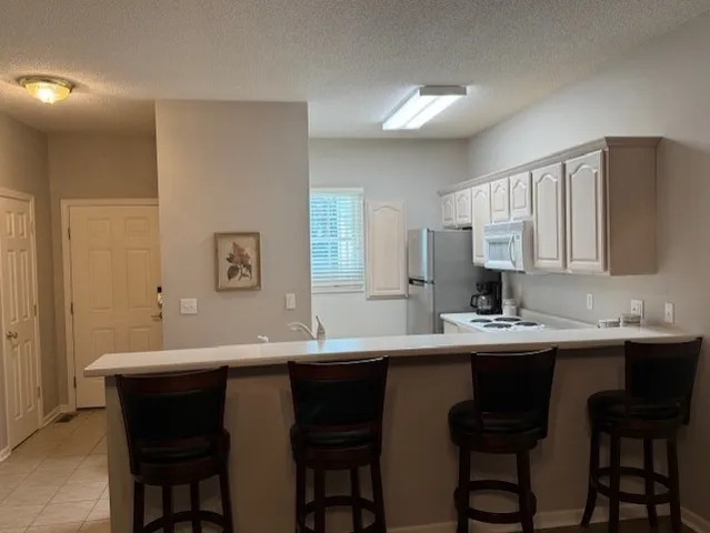 a kitchen with a sink and chairs