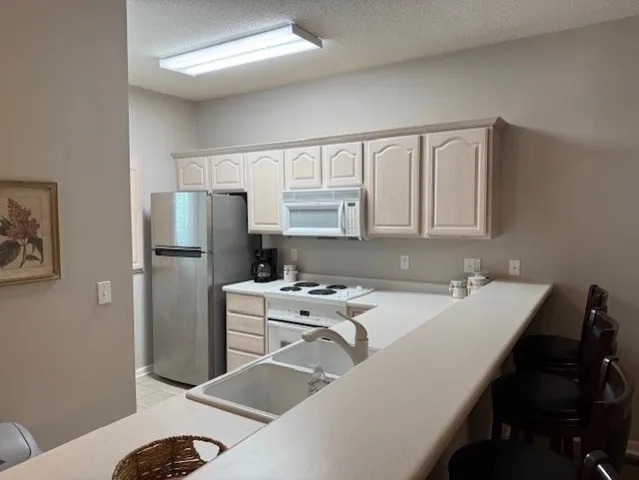 a room with a table chairs and refrigerator