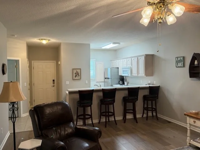 a living room with furniture a dining table and a chandelier