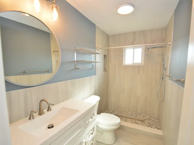 a bathroom with a sink toilet a mirror and shower