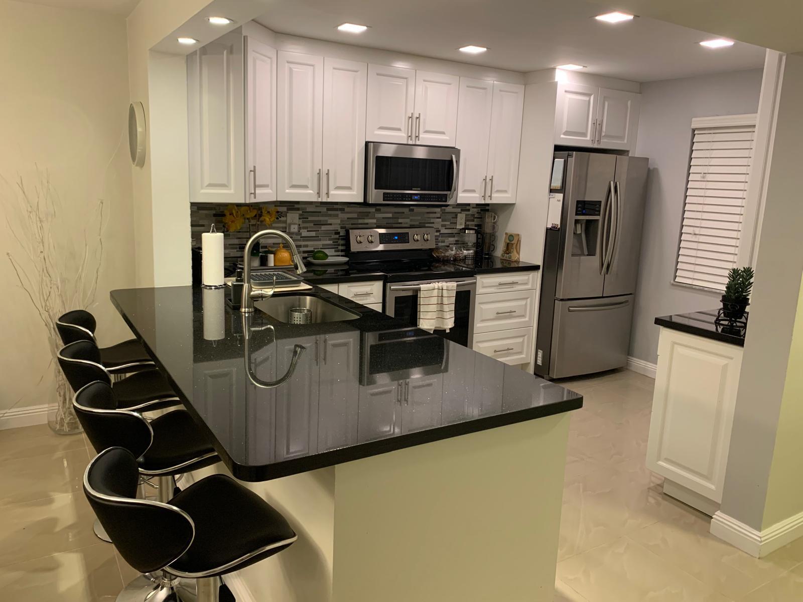 3940 Inverrary Boulevard, Unit 302A Lauderhill, FL 33319 - Photo 16 of 33 a kitchen with kitchen island a appliances and a refrigerator