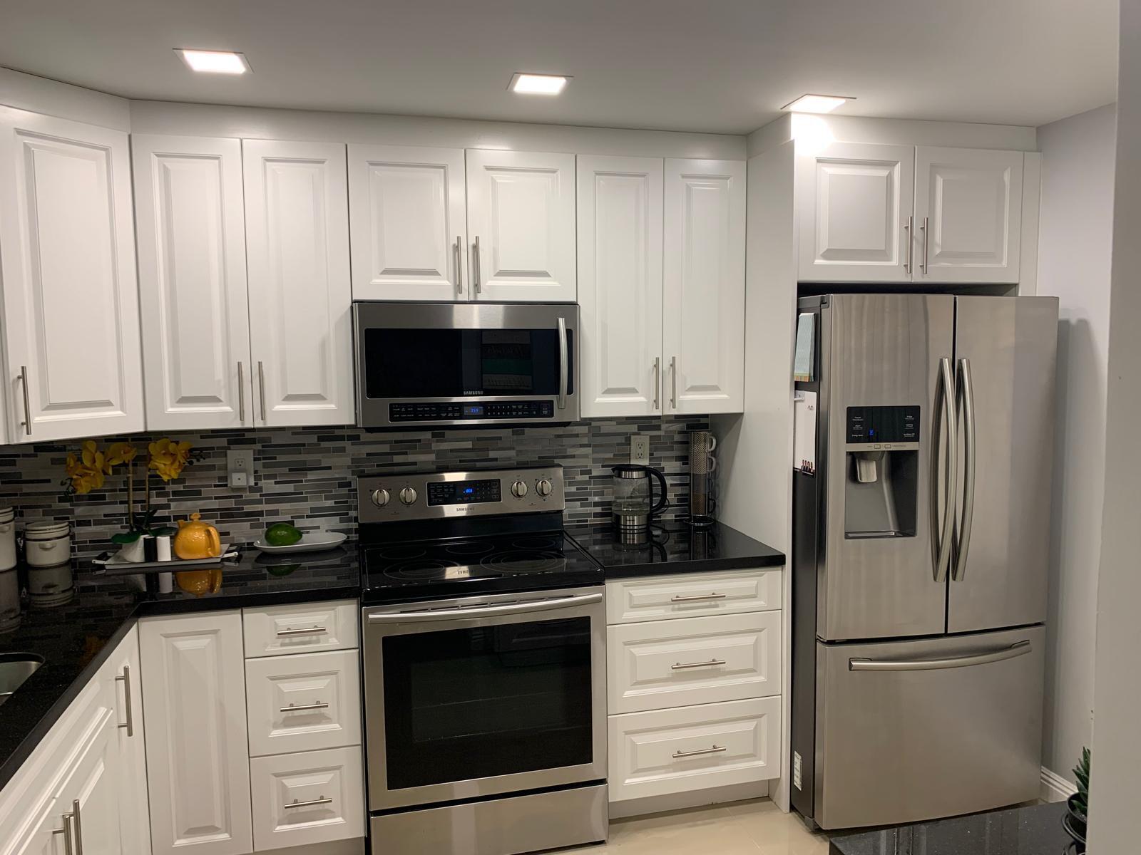 3940 Inverrary Boulevard, Unit 302A Lauderhill, FL 33319 - Photo 21 of 33 a kitchen with white cabinets and stainless steel appliances