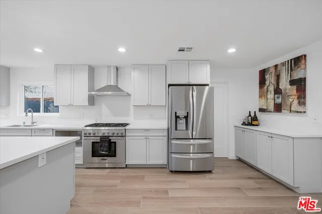 a kitchen with stainless steel appliances a stove a sink and a refrigerator