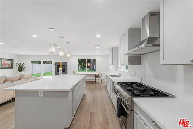 a kitchen with stainless steel appliances sink stove and cabinets