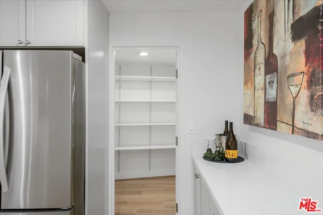 a view of a walk in closet with clothes and shoes