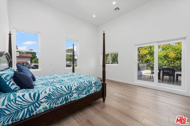 a bedroom with a bed window and a wooden floor