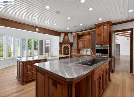 a kitchen with kitchen island a counter top space a sink stainless steel appliances and cabinets