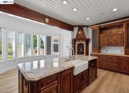 an empty room with wooden floor and ceiling fan