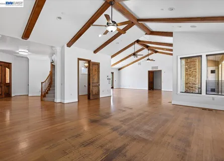 a view of a livingroom with wooden floor and stairs
