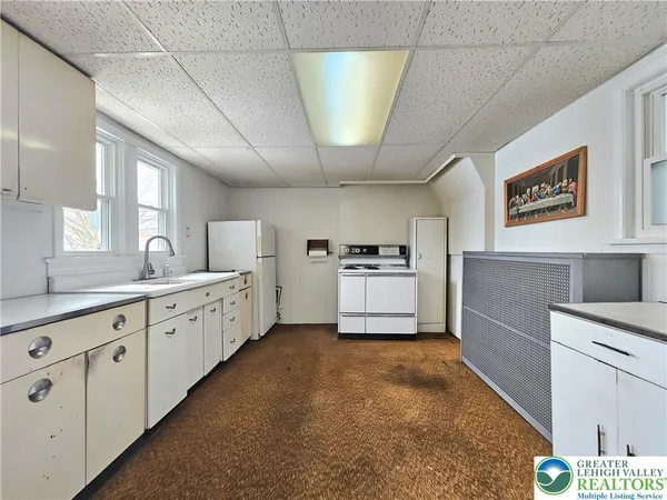 a large white kitchen with cabinets