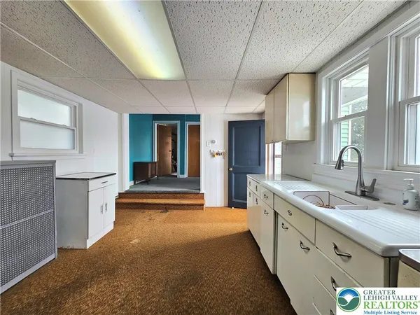 a large kitchen with kitchen island a sink stainless steel appliances and cabinets
