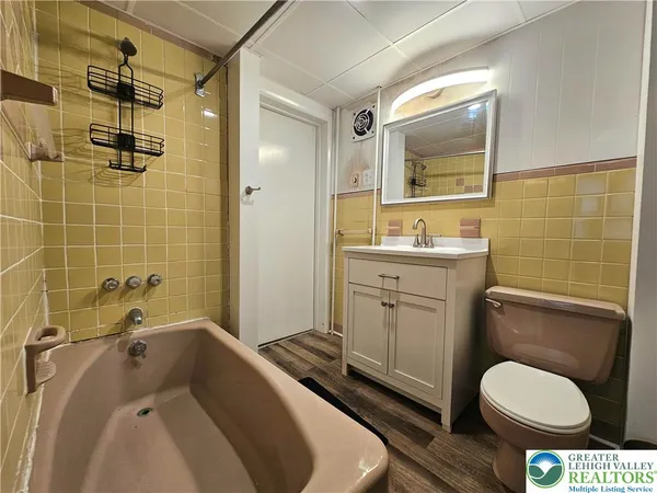 a bathroom with a granite countertop toilet sink and mirror