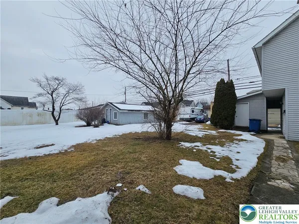 a view of a yard with snow on the road
