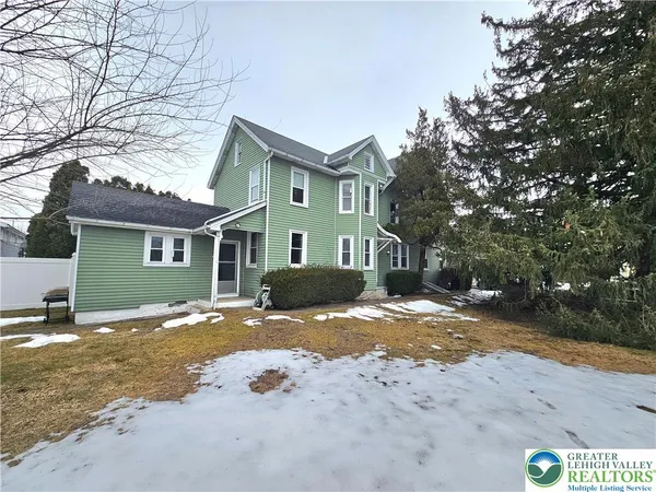 a view of a house with a yard covered in snow