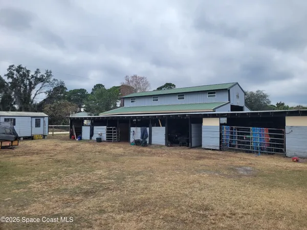 a view of a house with a big yard and large tree