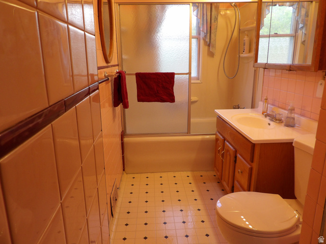 57 C Street Helper, UT 84526 - Photo 32 of 62 Bathroom with combined bath / shower with glass door, vanity, light floors, tile walls, and plenty of natural light