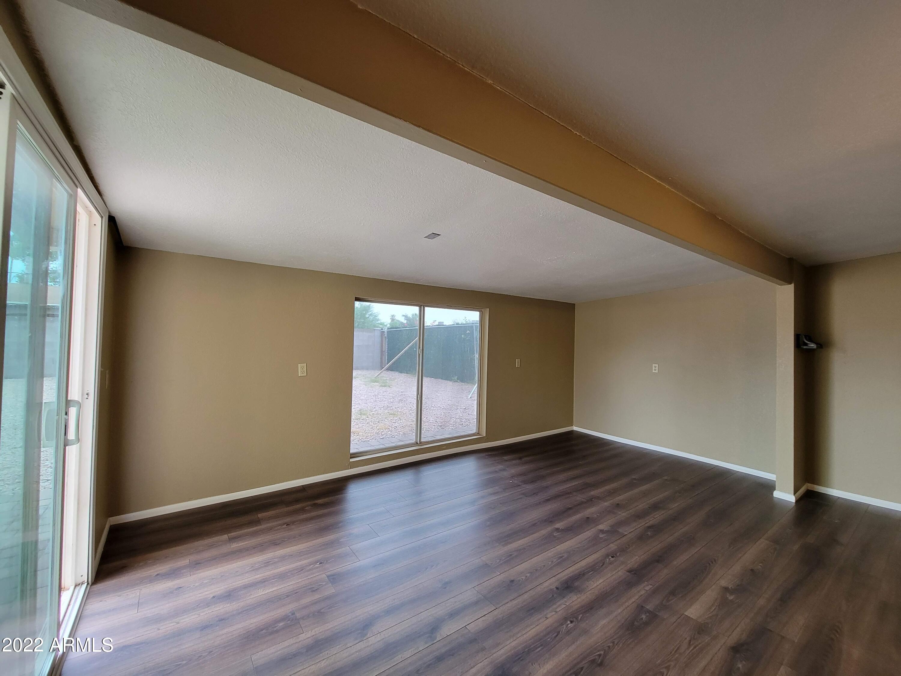 2042 West Decatur Street Mesa, AZ 85201 - Photo 11 of 38 an empty room with wooden floor and windows