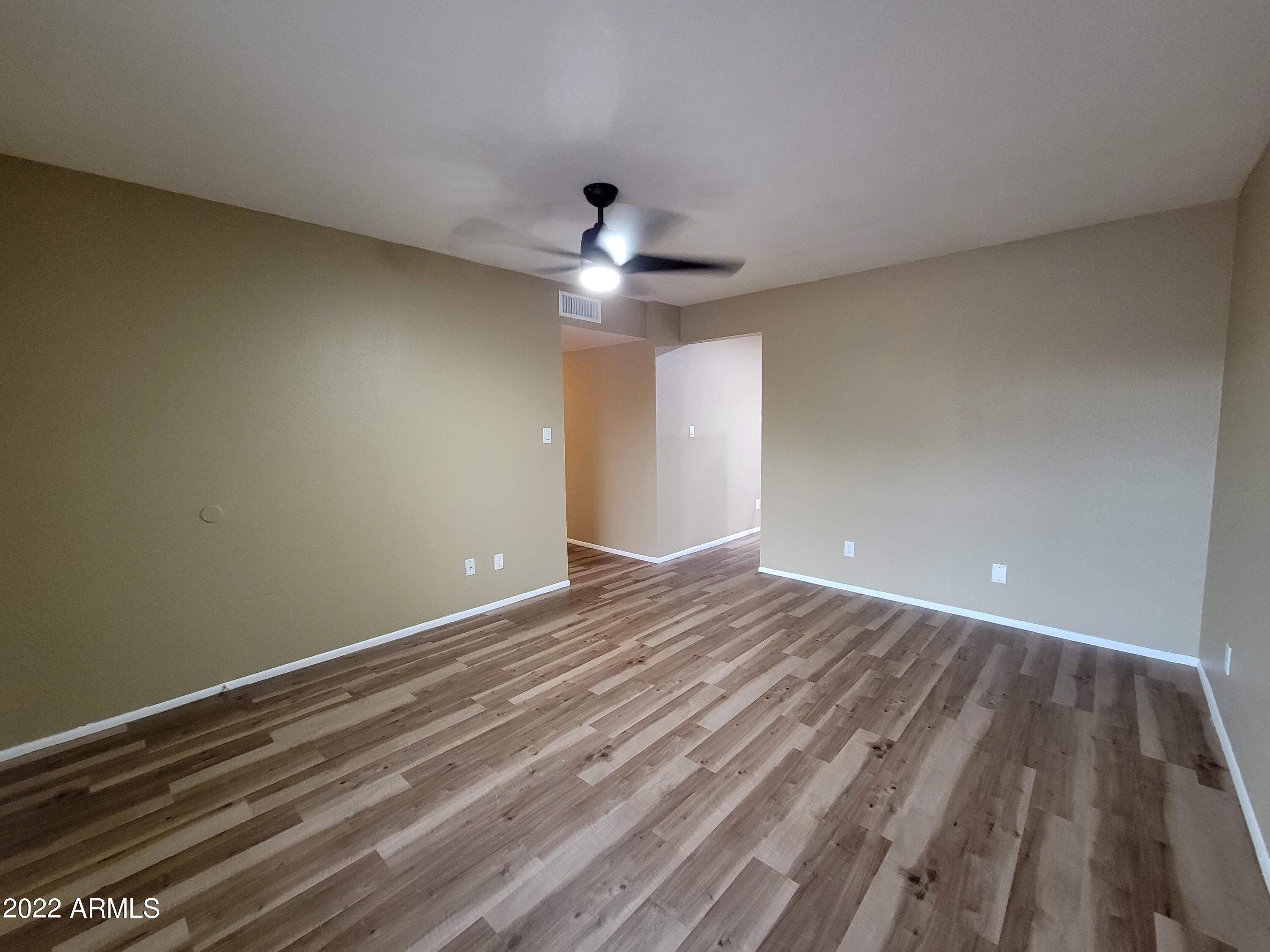 2042 West Decatur Street Mesa, AZ 85201 - Photo 14 of 38 a view of an empty room with wooden floor and a ceiling fan