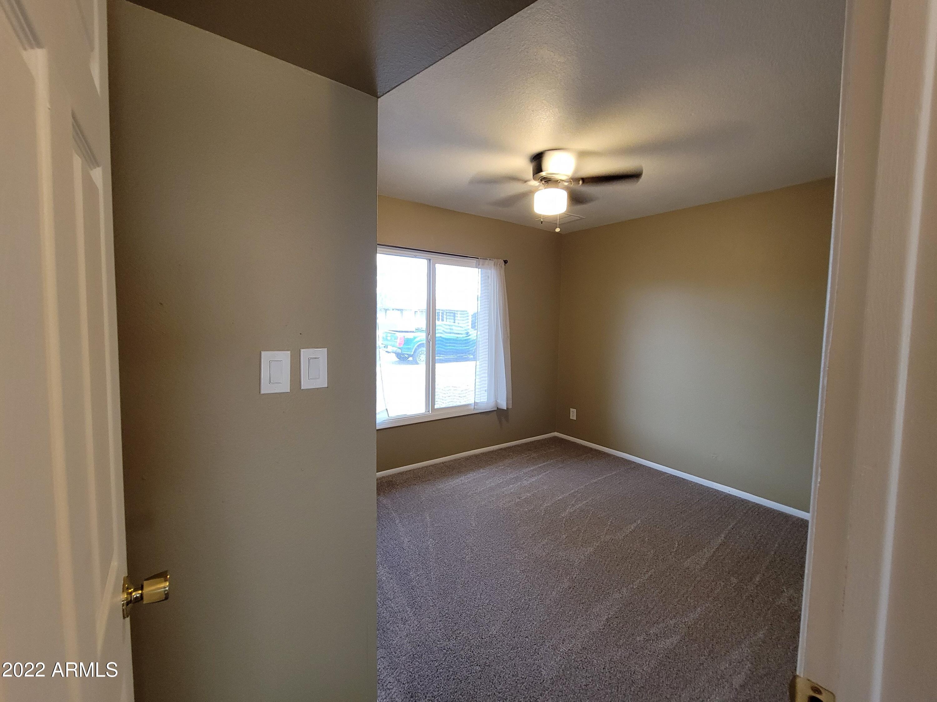 2042 West Decatur Street Mesa, AZ 85201 - Photo 32 of 38 an empty room with windows and chandelier fan