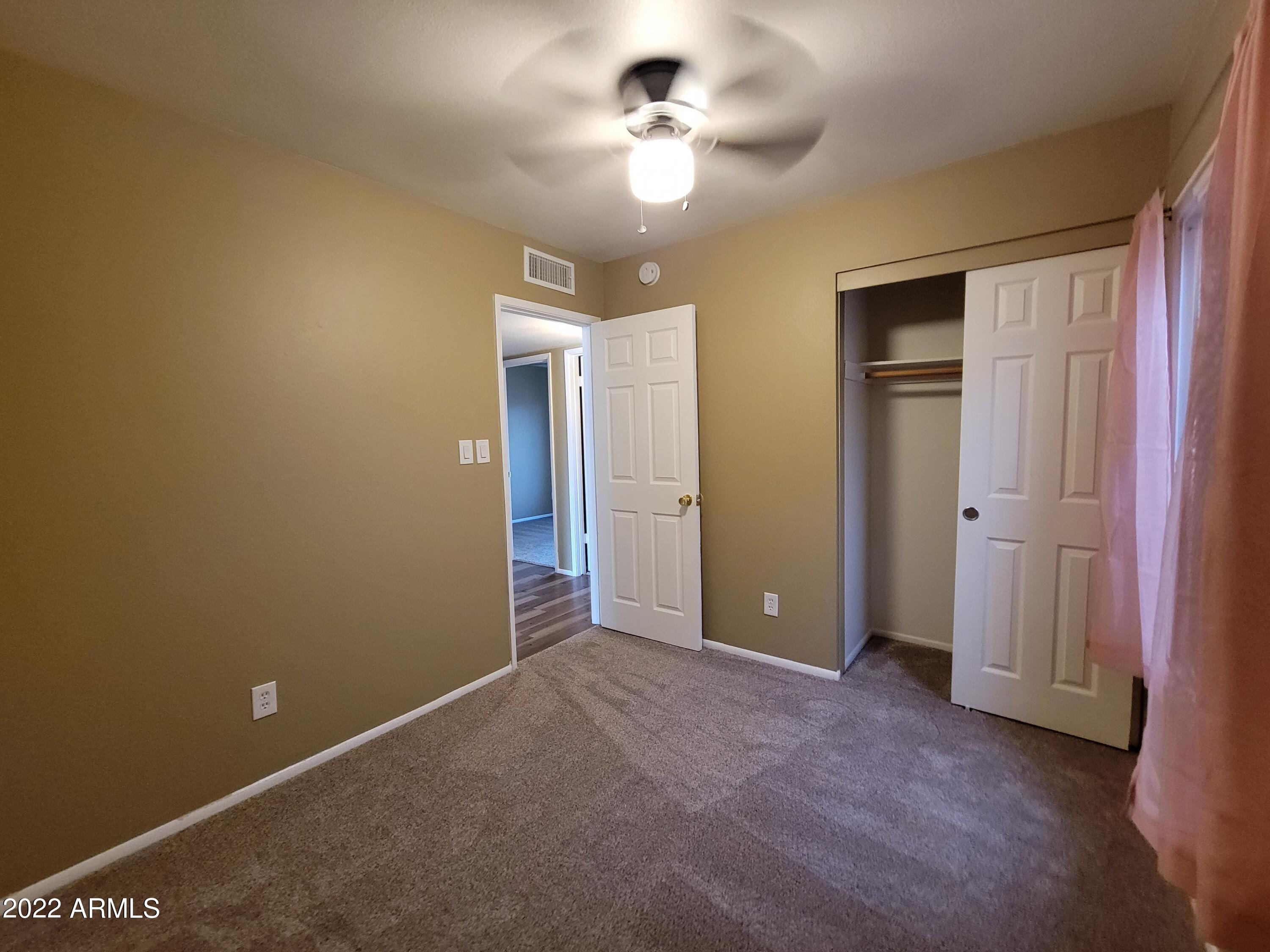 2042 West Decatur Street Mesa, AZ 85201 - Photo 34 of 38 an empty room with a ceiling fan and a window