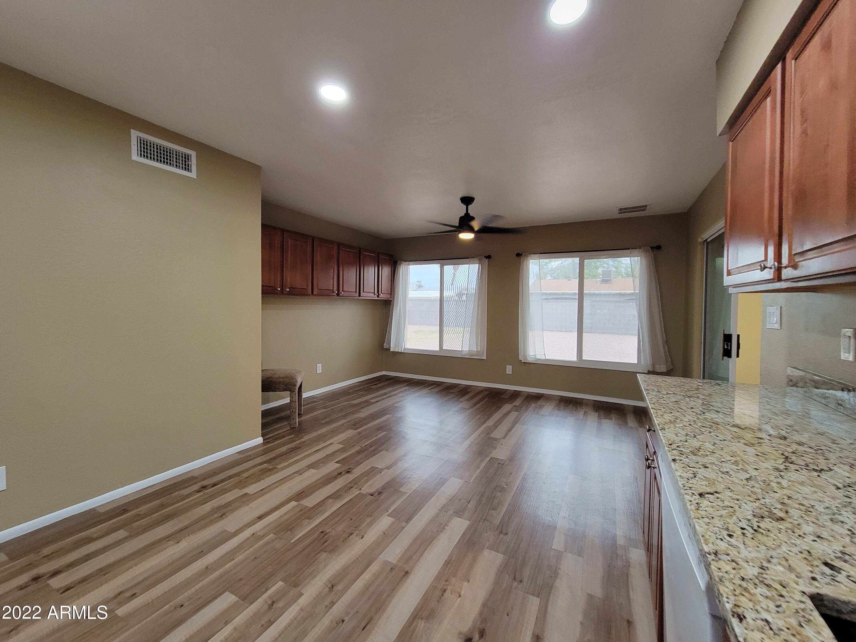 2042 West Decatur Street Mesa, AZ 85201 - Photo 10 of 38 an empty room with wooden floor and windows