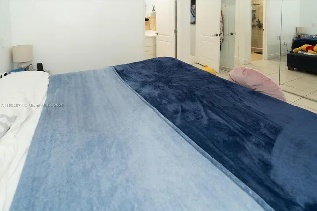 a spacious bedroom with a bed and wooden floor