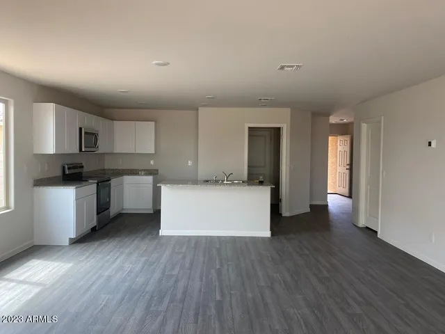 a kitchen with stainless steel appliances white cabinets and wooden floor