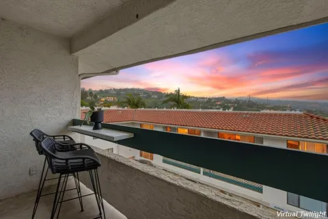 a view of balcony with furniture and city view