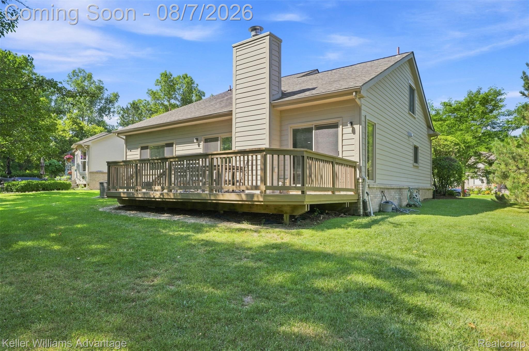 5325 Simpson Lake Road West Bloomfield, MI 48323 - Photo 31 of 43 Expansive backyard featuring a large wooden deck, mature trees, and a well-maintained lawn