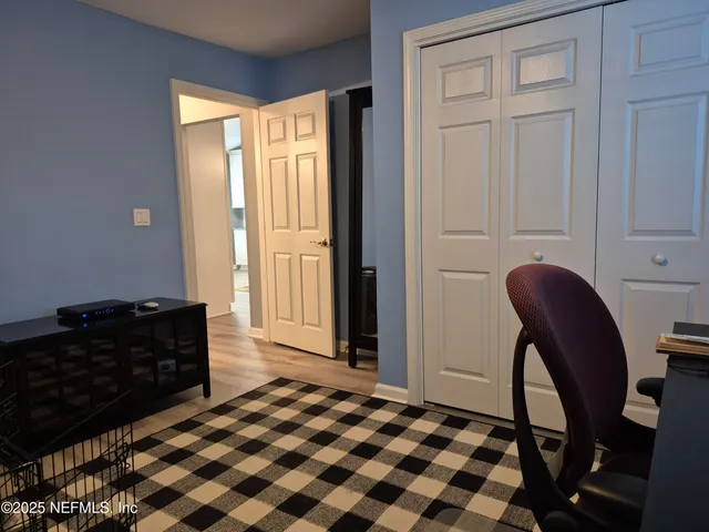 a bedroom with a bed and a dresser next to a window