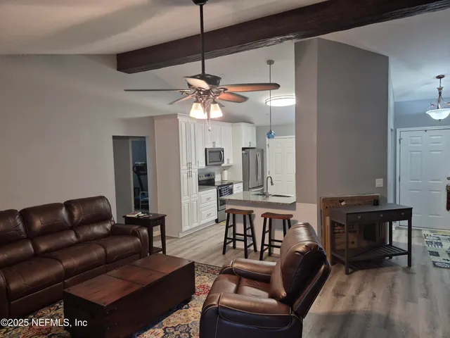 a living room with furniture a fireplace and a chandelier