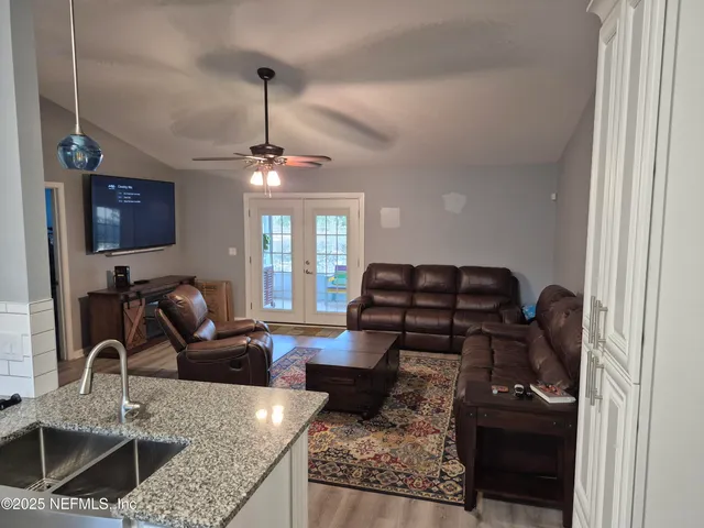 a living room with furniture a flat screen tv and kitchen view
